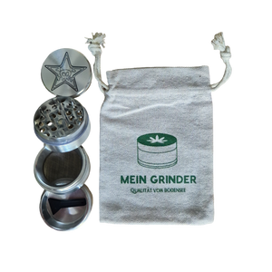 Silberner Grinder mit Gravur in 4 Teilen neben Baumwollsäckchen als Kiffer Geschenk